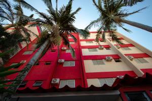 卡萨帕瓦Plaza Dutra Hotel的一座红色的建筑,前面有棕榈树