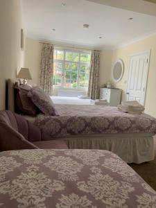 剑桥列文顿别墅酒店的一间卧室设有两张床和窗户。