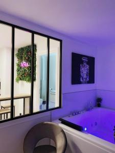 贝桑松L’appart[é] BLACK superbe appartement pop !的紫色浴室设有浴缸和大窗户