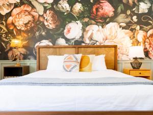 棕榈泉Fleur Noire Hotel的卧室配有花卉壁纸和床