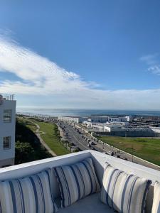 丹吉尔Tanger *Maison avec terrasse et vue sur la mer *的大楼顶层带枕头的阳台