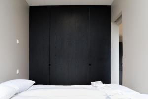 阿克雷里Geirþrúðarhagi one bedroom apartment的一间卧室配有黑色床头板和白色的床