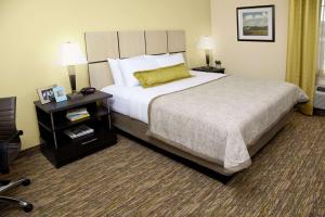 沃思堡Sonesta Simply Suites Fort Worth的酒店客房设有一张大床和一个床头柜。