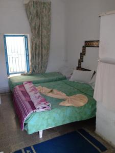 乌姆苏克新巴达酒店的一间卧室设有两张床和窗户。