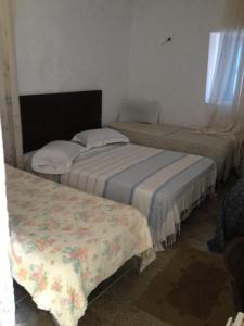 乌姆苏克新巴达酒店的带窗户的客房内设有两张单人床。