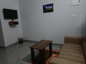 瓦亚纳德Wayanad Vista Service Apartment的客厅配有沙发和桌子