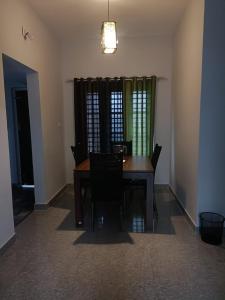 瓦亚纳德Wayanad Vista Service Apartment的一间带木桌和椅子的用餐室