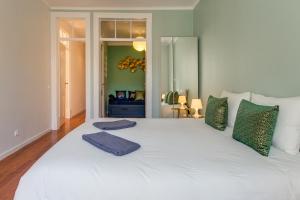 里斯本Spacious, Bright and Newly Renovated 2 Bedroom Apartment, Lisbon Historical Center, Madragoa的一张带绿色枕头的大型白色床