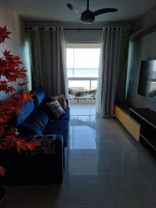 卡波布里奥Apartamento Vista Mar – Pé na Areia的客厅配有蓝色的沙发和电视