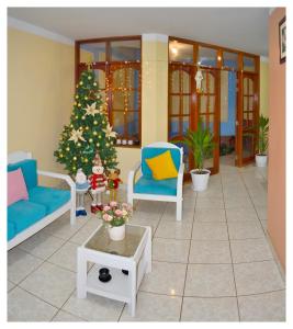 Urbanizacion Buenos AiresHospedaje La Casa Blanca的客厅配有圣诞树和蓝色椅子