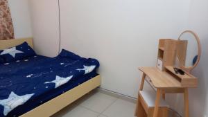 宜力Homestay Zaki D'Gerik的一间卧室配有一张带蓝色棉被的床和一张桌子