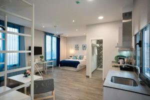 科尔多瓦EM21 Apartamentos的一间厨房和客厅,客厅内配有一张床