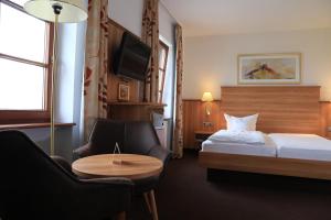 巴特温普芬Neckarblick SELF Check IN Hotel的酒店客房带一张床、一张桌子和椅子