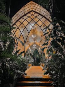 卢纳将军城Tropical Temple Siargao Resort的一座大型建筑,拥有木天花板和植物