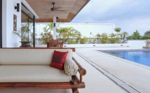 高兰Kulraya Villas - Luxury Serviced Pool Villas的带沙发和游泳池的客厅