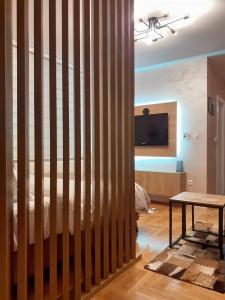 帕莱Apartman Planinski Kutak的配有木隔板、床和桌子的房间