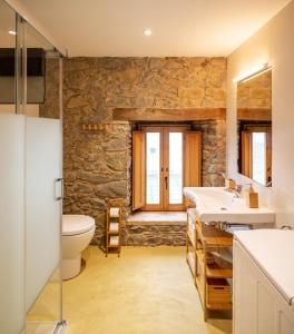 Sant Pere de TorellóEl Rebastral - Mas Vinyoles Natura的浴室设有石墙、卫生间和水槽。