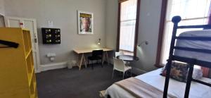 开普敦Ashanti Lodge Backpackers的一间卧室配有一张床、一张桌子和一张桌子