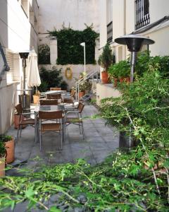 瓜达拉哈拉西班牙酒店的庭院配有桌椅和植物
