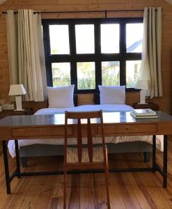 Tournedos-sur-SeineClairseine的一间卧室配有桌子、床和窗户