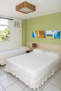 巴雷里尼亚斯Gran Lençóis Flat Residence 2 suítes com sala的绿墙客房内的两张床