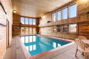 博伊西机场品质酒店的一座带木墙和窗户的别墅内的游泳池