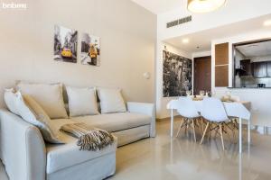 迪拜bnbmehomes - Great Value Spacious Apartment w Moden Furniture - 103的客厅配有沙发和桌子