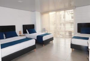 波帕扬Hotel Monarka-Edificio的一间卧室设有两张床和大窗户