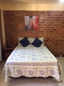 里约热内卢Pousada OASIS DO BARRAL的一间卧室配有一张砖墙床