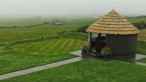 金塞尔Ocean View,Kinsale, Exquisite holiday homes, sleeps 22的田野上带草屋顶的凉亭