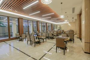 大雅台Hotel Casiana Tagaytay Managed by HII的用餐室设有桌椅和窗户。