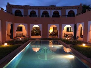 阿加迪尔Riad Asmaa Agadir的一座在晚上设有游泳池的大房子