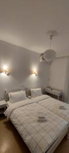 卢特拉艾季普苏Hotel Rania的一间卧室配有一张带两盏灯的大型白色床。