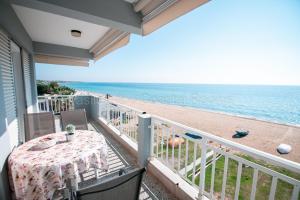 弗洛伊塔Vasileiadou Coastal Rooms的阳台配有桌子,享有海滩美景