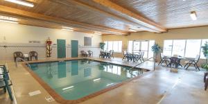 马凯特Holiday Inn Express & Suites Marquette, an IHG Hotel的一座带桌椅的游泳池