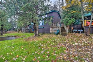 萨拉纳克莱克Pet-Friendly Adirondack Cabin with On-Site Lake的院子里有树叶的房子