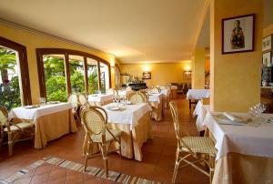 卡拉费尔安提加酒店的餐厅设有白色的桌椅和窗户。
