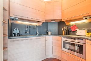 塞斯特雷Terrazza su Sestriere Lux的厨房配有木制橱柜和不锈钢用具