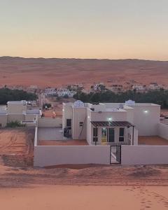 Al RakaPrivate Sand Bond的沙漠中的一个白色房子