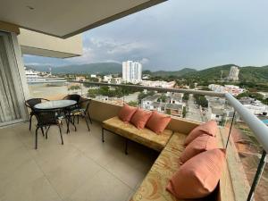 圣玛尔塔Rodadero Sur Confortable的阳台配有沙发和桌椅。