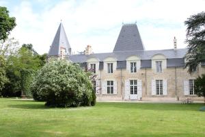 BouayeChâteau du Bois de La Noe的草坪上一座有两座塔楼的老房子