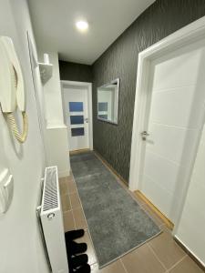 帕莱Apartman Enjoy的一条带白色门和电话的走廊