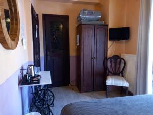 卡兰巴卡神话宾馆的一间卧室配有木制橱柜和椅子
