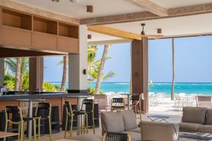 蓬塔卡纳Caribe Deluxe Princess - All Inclusive的一个带椅子的海景酒吧