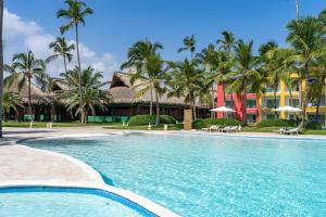 蓬塔卡纳Caribe Deluxe Princess - All Inclusive的棕榈树度假村前的游泳池