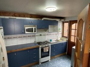 比亚里卡Casa Centro Villarrica的厨房配有蓝色橱柜和炉灶烤箱。