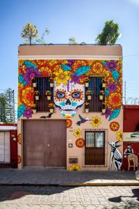 瓦哈卡市La Casa de Pino的一座建筑,上面有彩绘的头骨和花朵