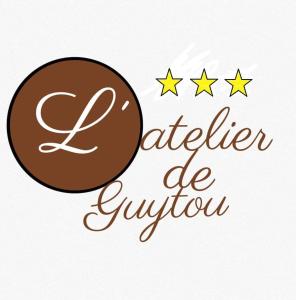 谢瓦布朗克L'atelier de Guytou et Spa的一家面包店的标志,上面有巧克力甜甜圈和三颗星