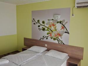 切尔诺莫雷茨Morska Zvezda Guest House的卧室配有一张挂着花壁画的床。