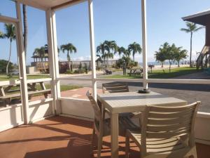 伊斯拉莫拉达Ragged Edge Resort & Marina的海滩景门廊内的桌椅